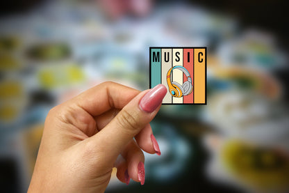 a woman&#39;s hand holding up a sticker with the word music on it