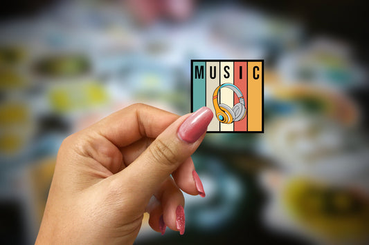 a woman&#39;s hand holding up a sticker with the word music on it